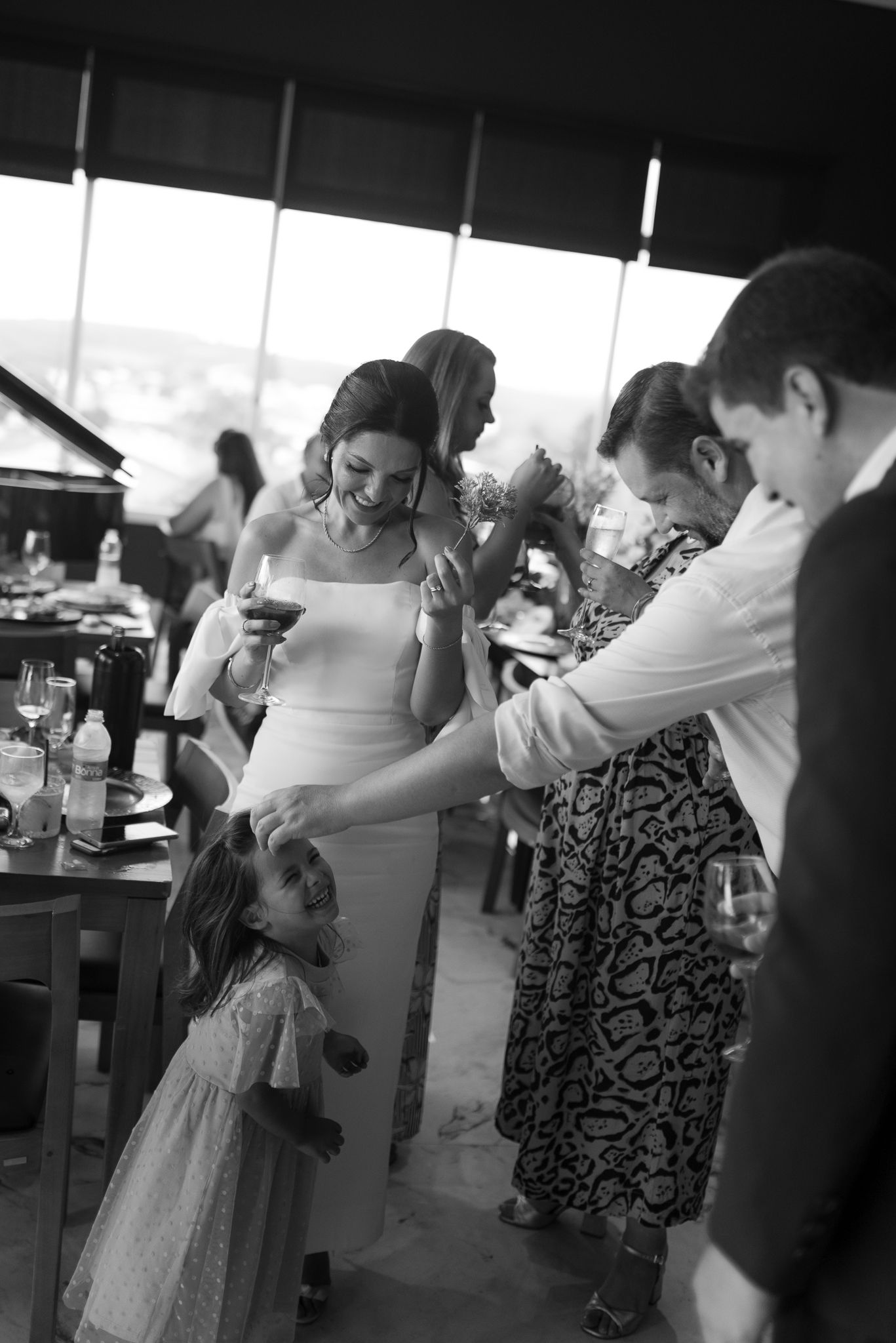 Black and white candid reception photo of guests enjoying celebration.