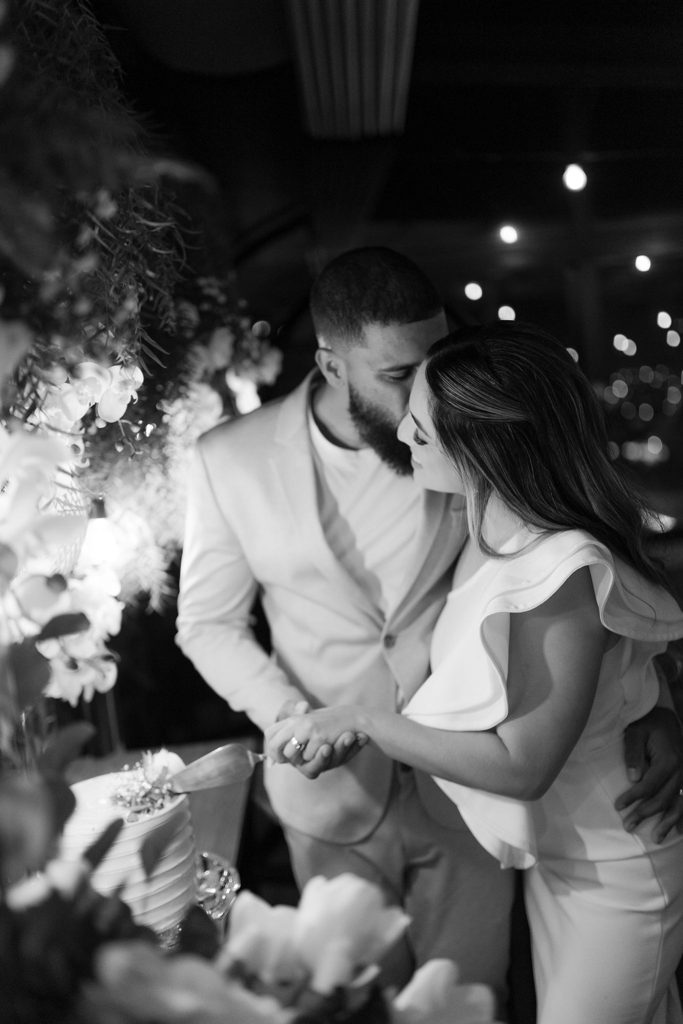 A romantic black and white photo sequence captures tender moments between a couple in white attire at their wedding.