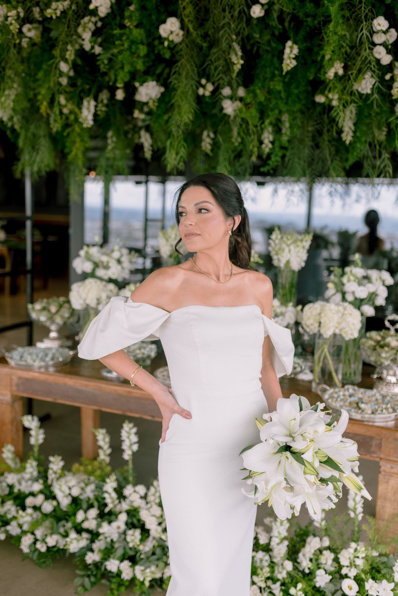 Bridal portraits in a white off-shoulder dress surrounded by floral decorations.