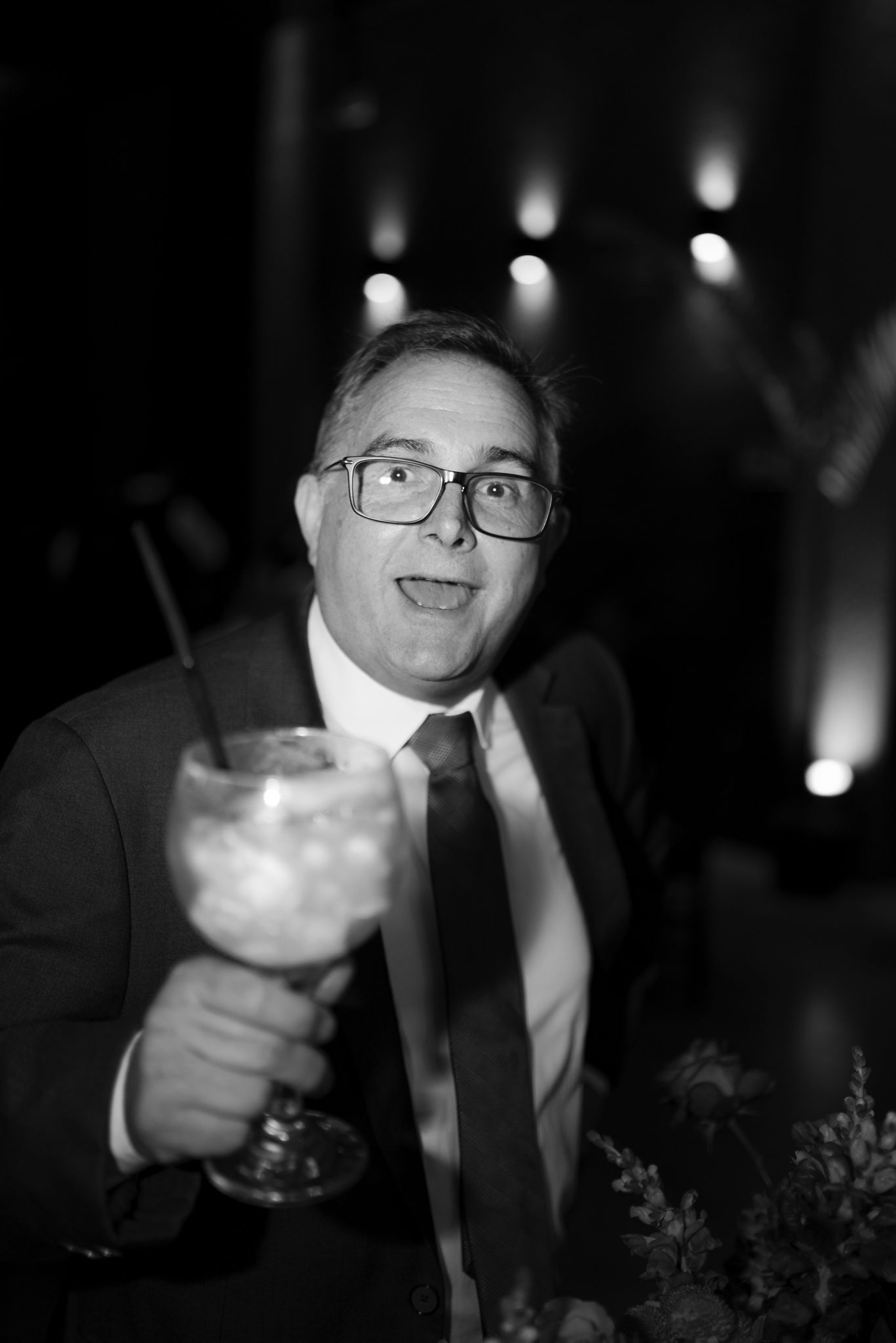 Black and white series of someone enjoying cocktails at an evening reception.