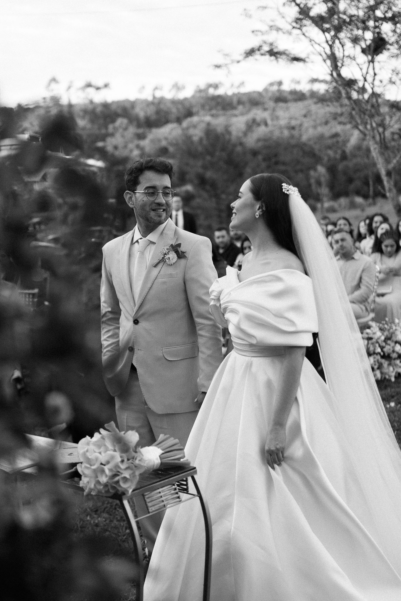 A joyful moment captured at an outdoor wedding ceremony as a couple in white and tan attire celebrates their union.