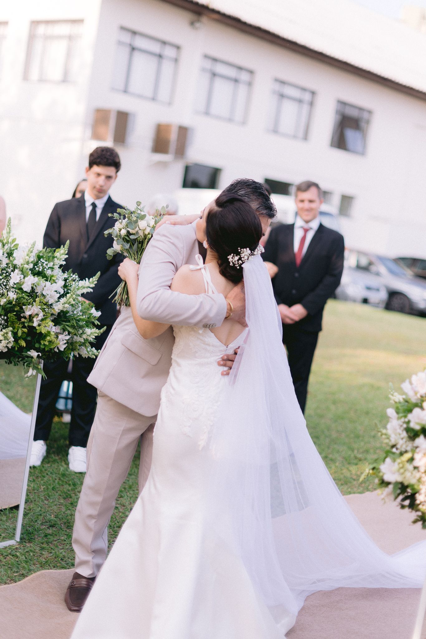 Emotional wedding ceremony moment outdoors with couple and wedding party.