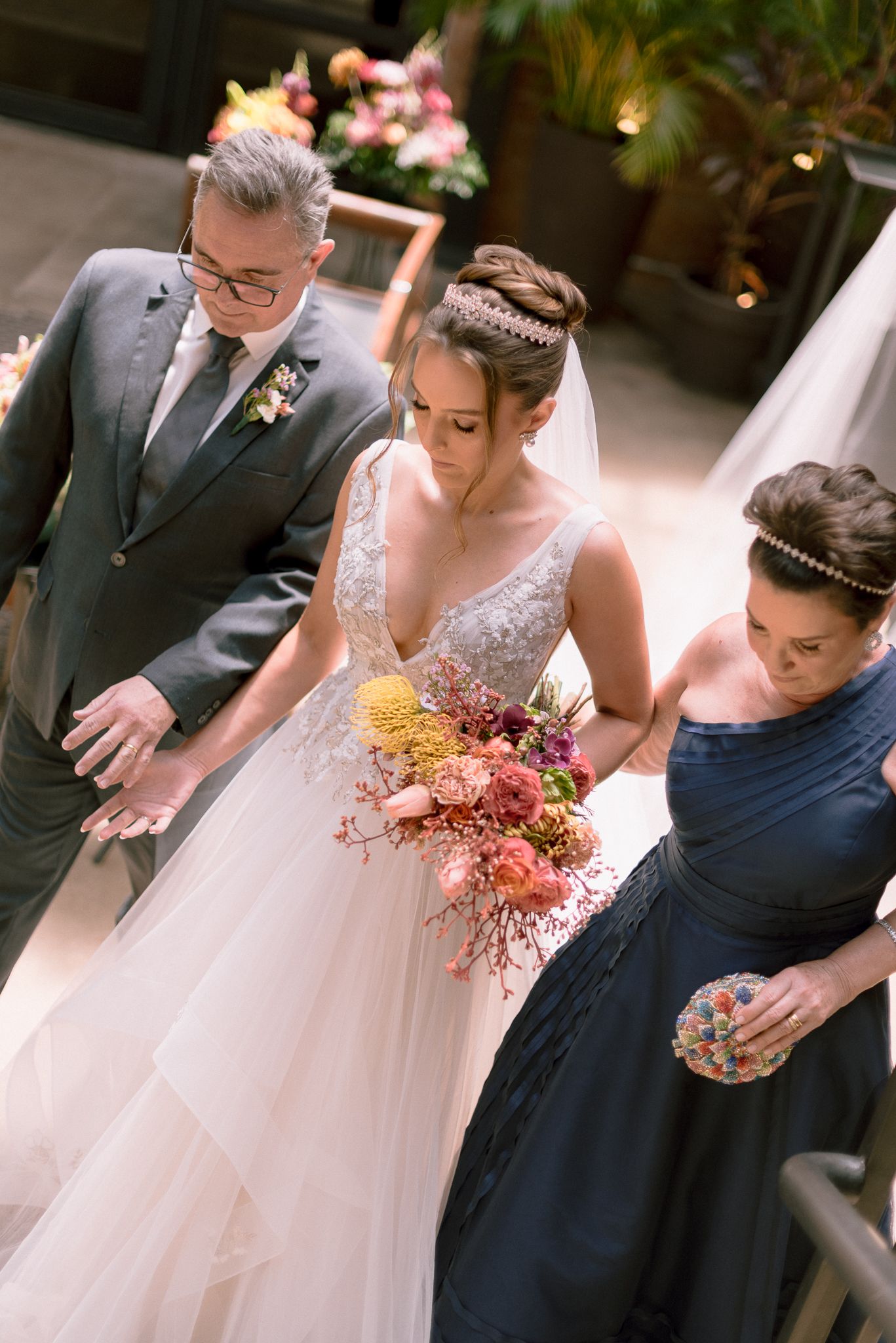 Wedding couple shares intimate moments with colorful autumn bouquet in outdoor garden setting.