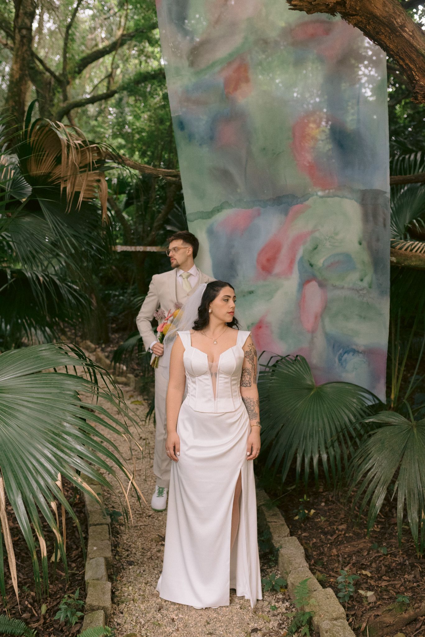 A collection of artistic portraits in a lush tropical garden setting with ethereal colored smoke effects.