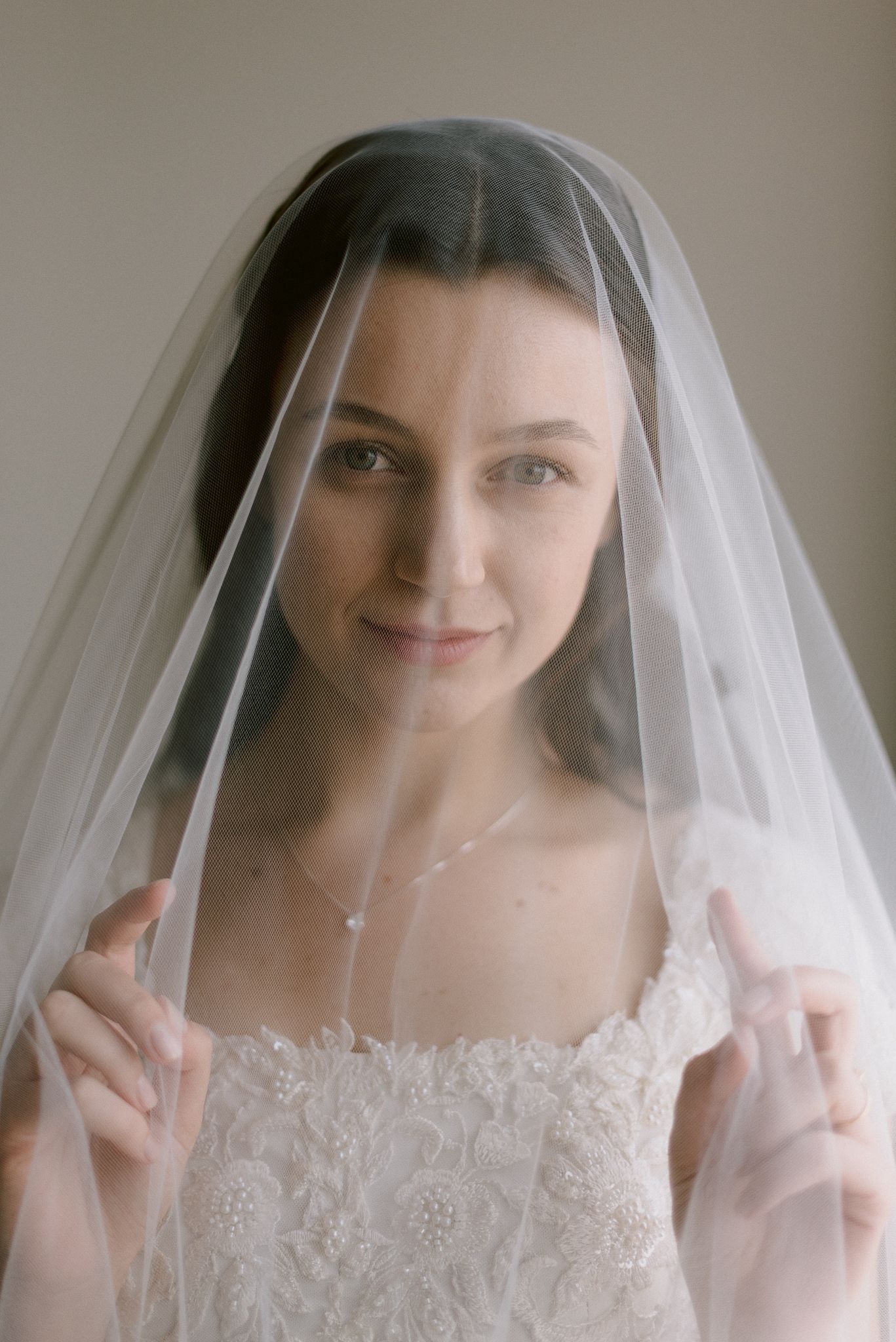 A bride lifts and adjusts her delicate white wedding veil in a progression of connected images.