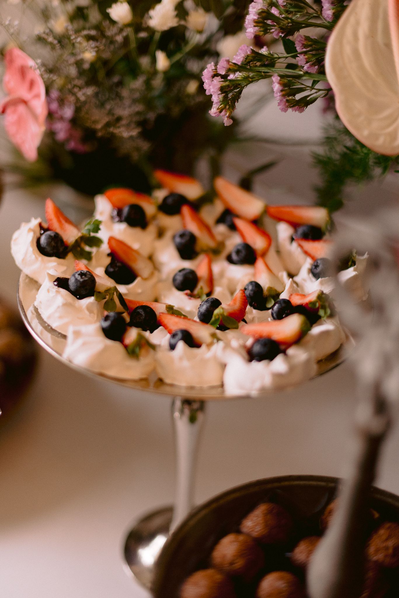 Elegant dessert platter with berries and cream served at wedding reception.