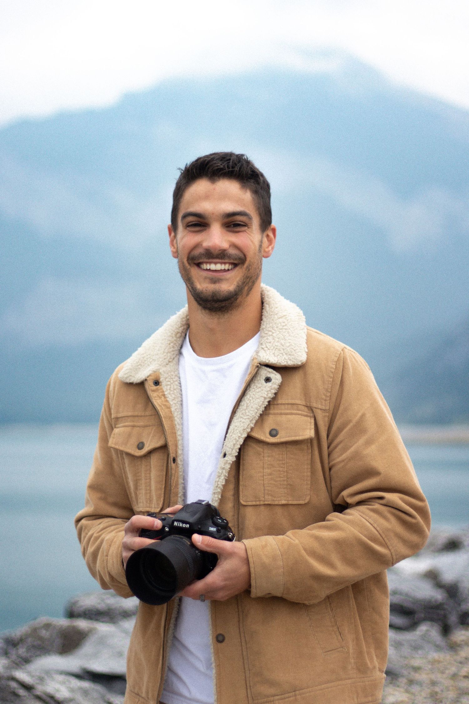 Professional headshot at Barrier Lake Alberta, outdoors with scenic lake and mountains in background