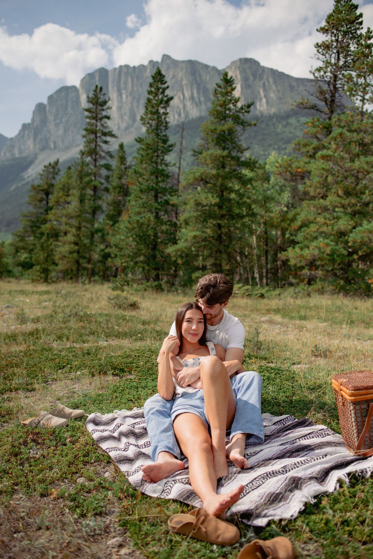 Engagement photography Yamnuska Alberta, couple enjoying picnic outdoors with mountain backdrop