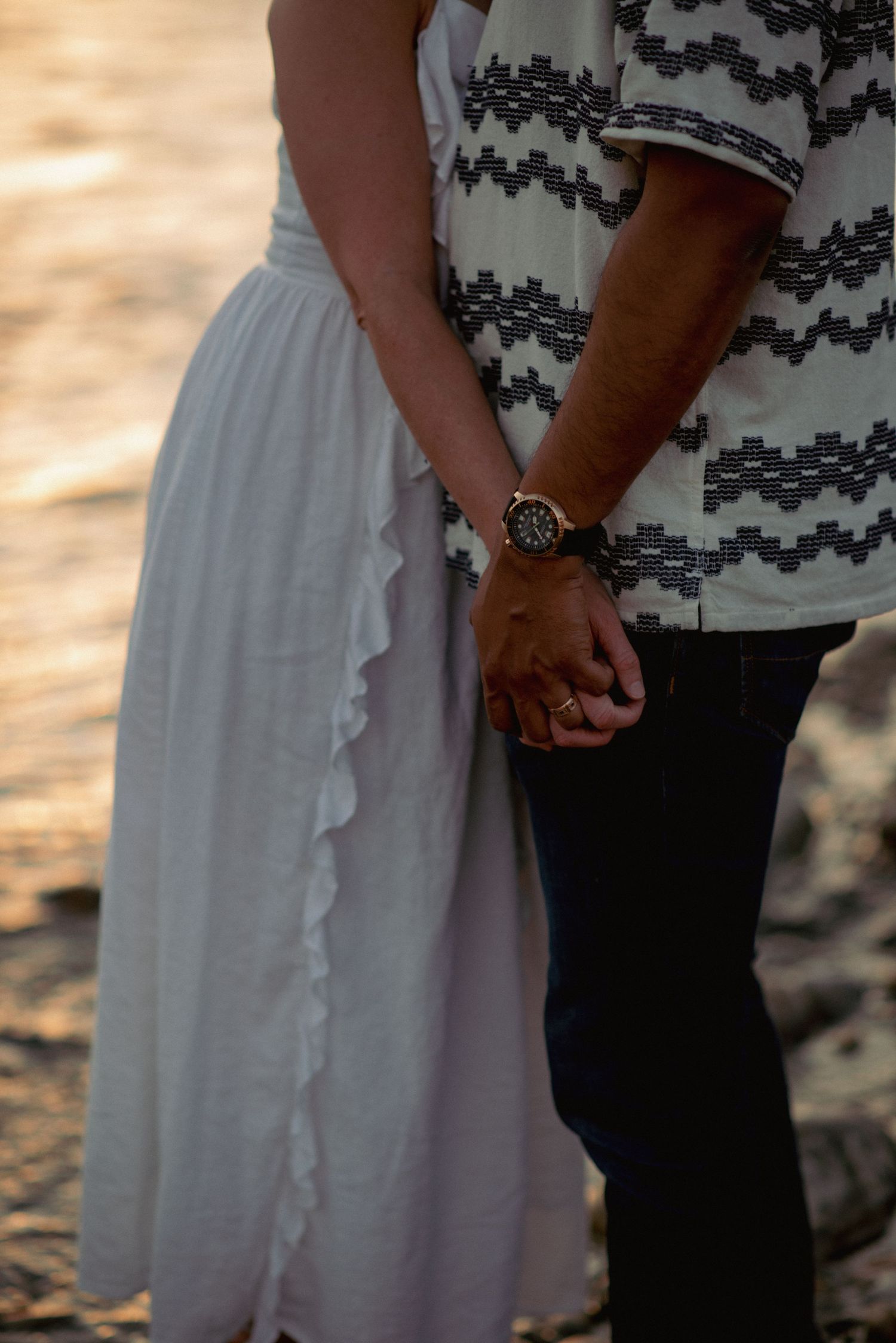 Candid couples photography Rocky Mountains, romantic hands-only shot by river near Cochrane