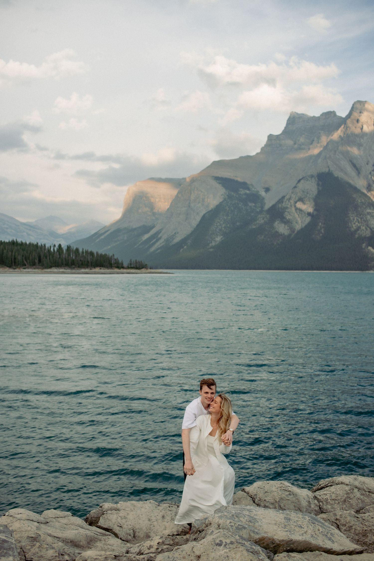 Couple photography Rocky Mountains Alberta, intimate moment shared in front of scenic mountain backdrop