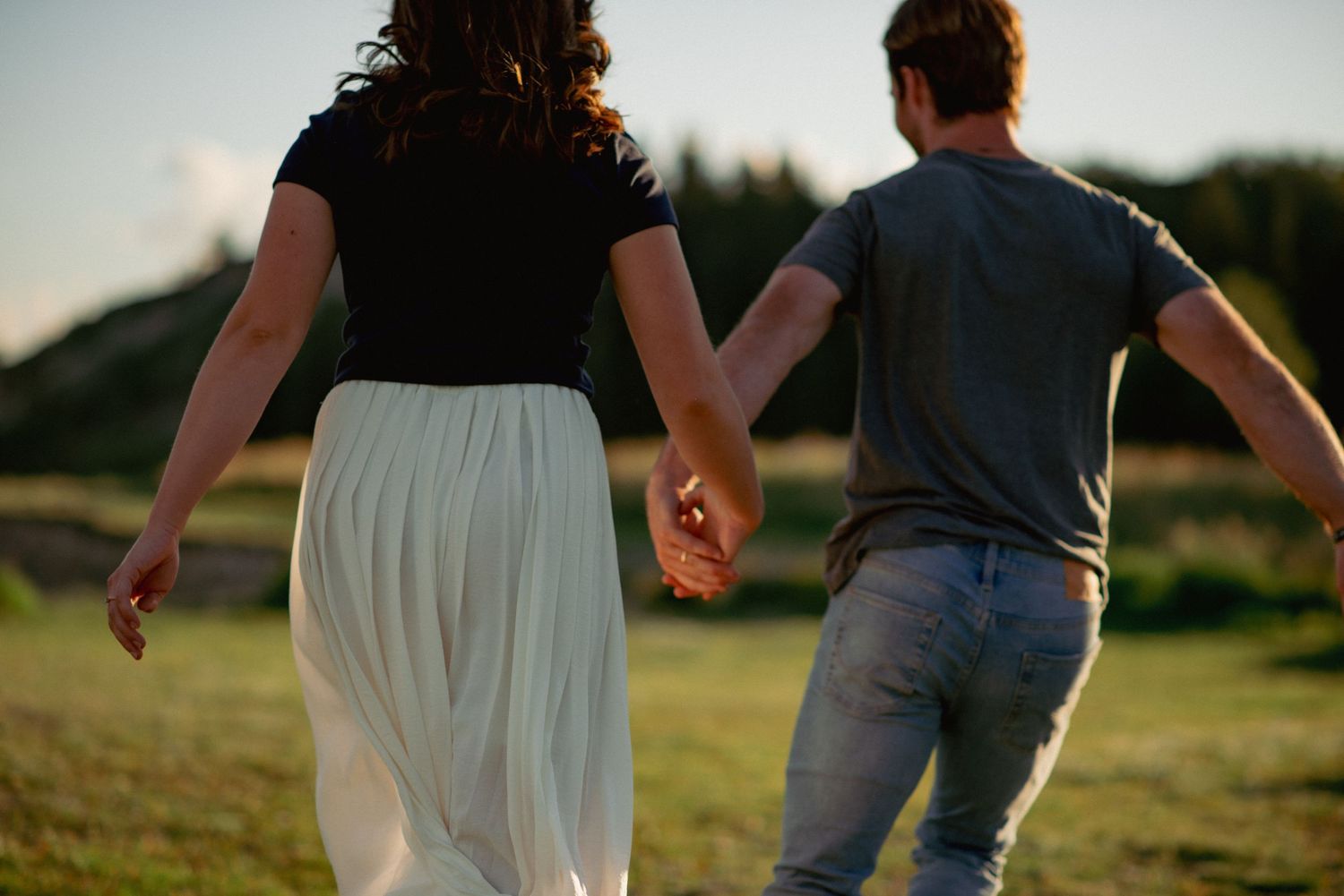 Candid couples photography Rocky Mountains, playful running moment of couple outdoors at Ghost Lake