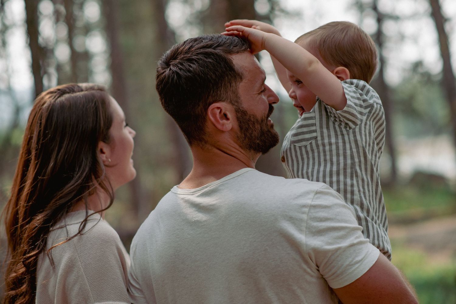 Alberta family photography, toddler son playing with dad’s hair in close-up candid shot