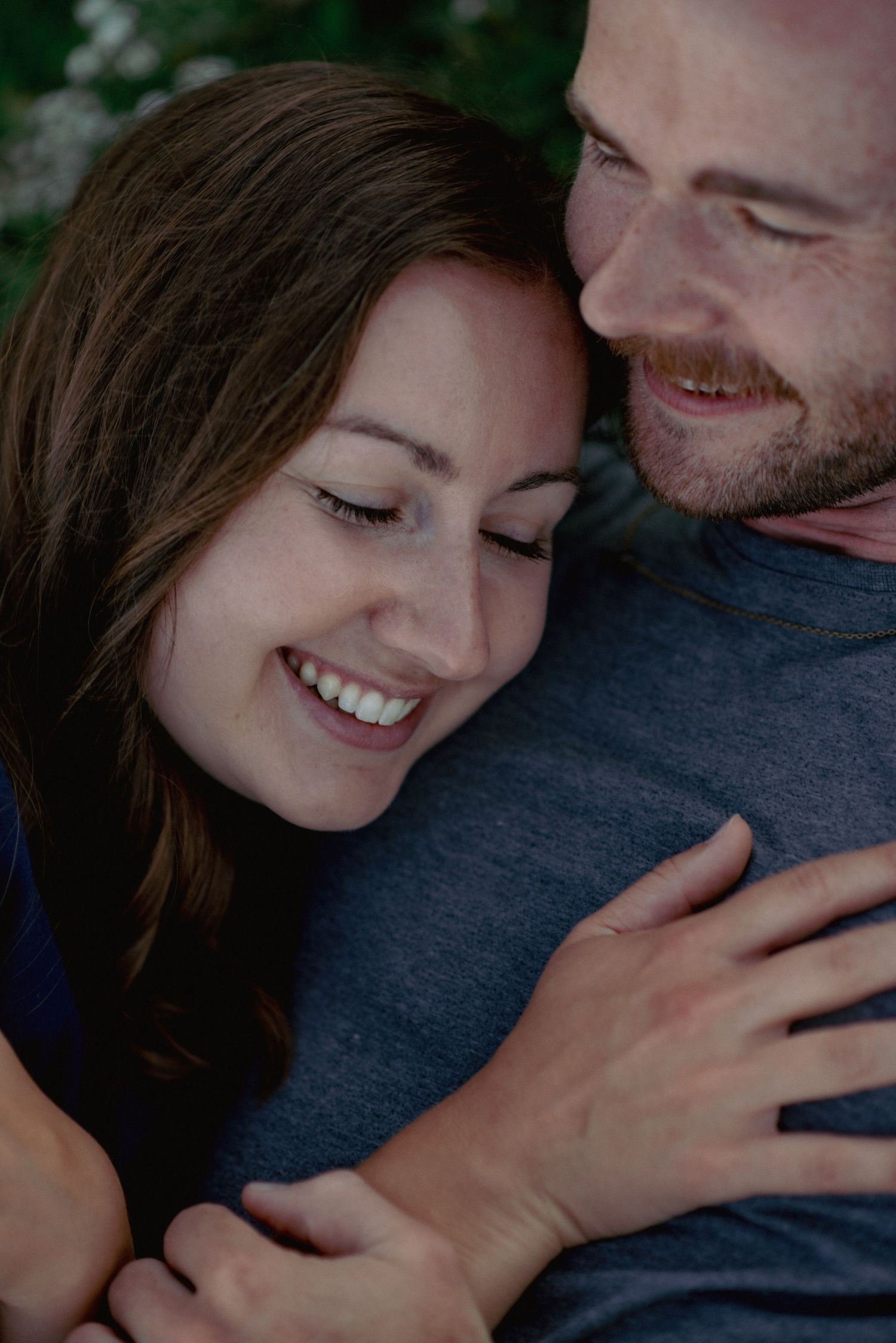 Couple photography Ghost Lake Alberta, partners embracing in front of scenic waters during outdoor session