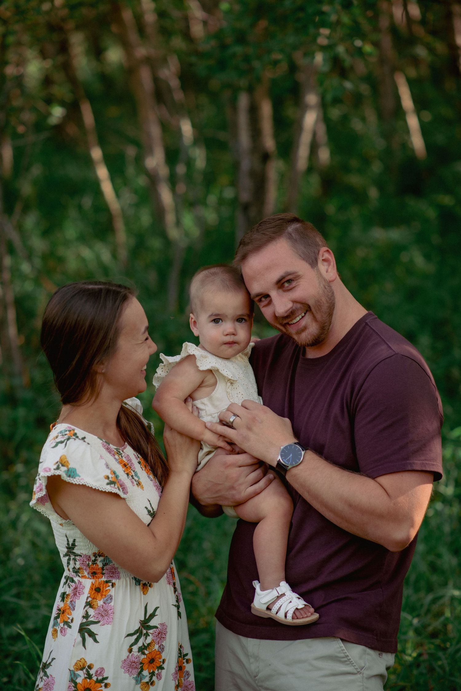 Calgary family photography in forested Nose Hill Park, parents interacting with toddler during outdoor session