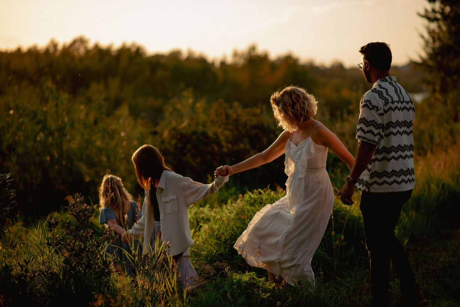 Cochrane family photographer capturing candid moments by the river at sunset.