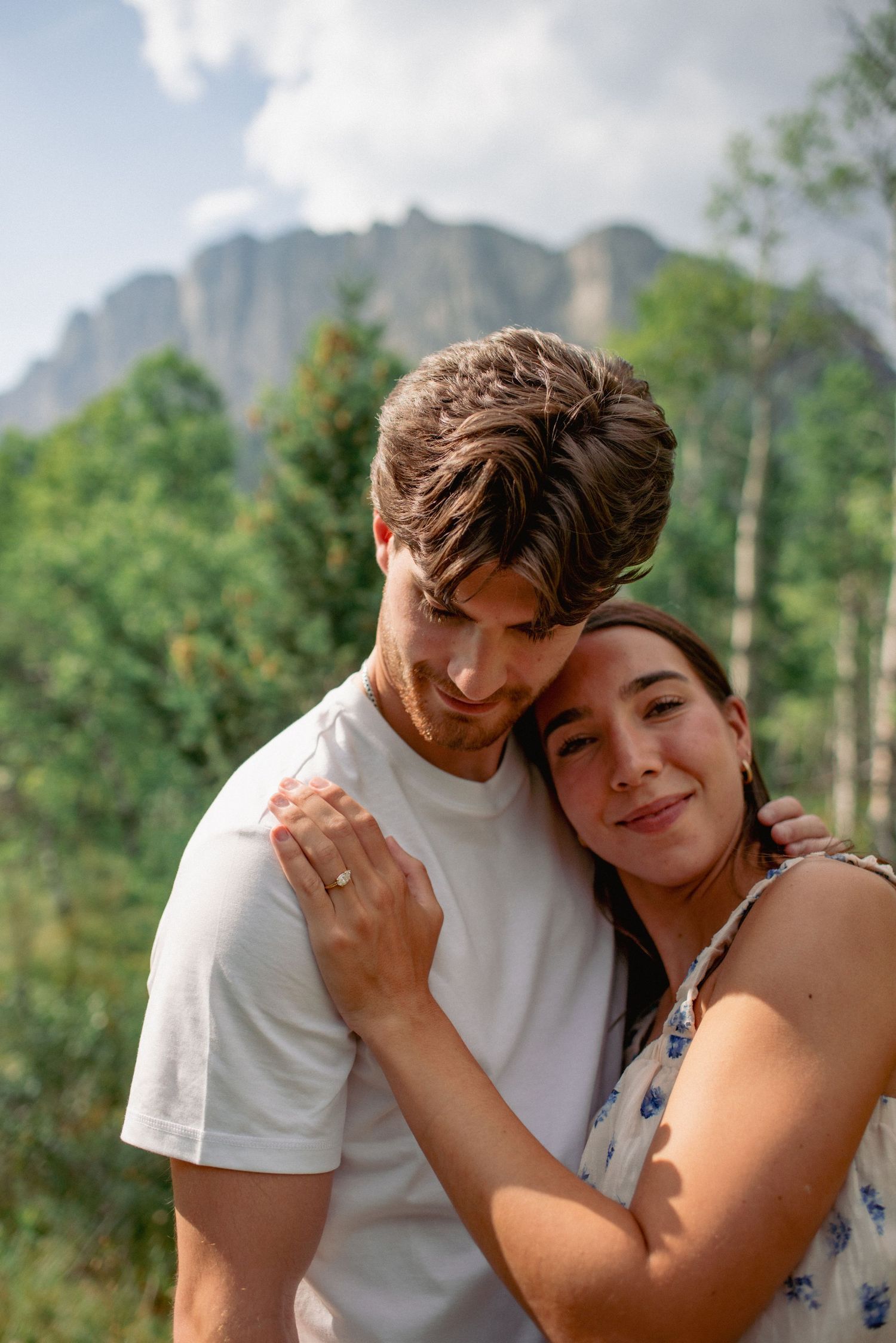 Outdoor engagement session Rocky Mountains Alberta, couple highlighting engagement ring in front of Yamnuska