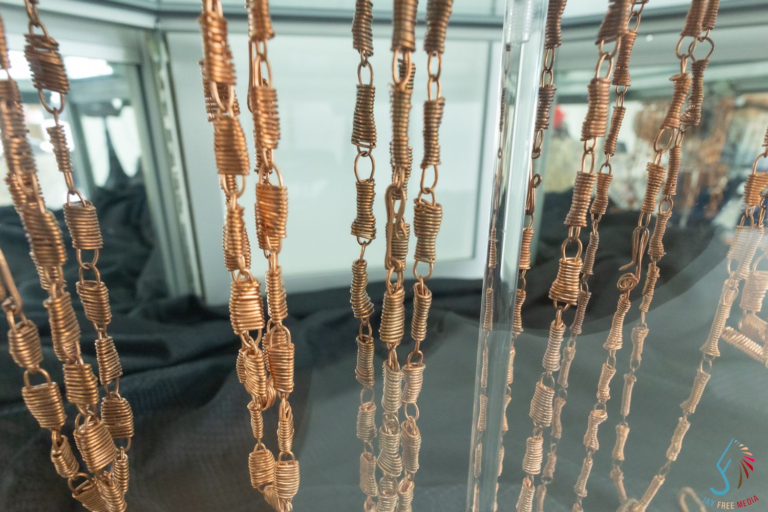 Handcrafted copper wire chain jewelry pieces hanging on display.