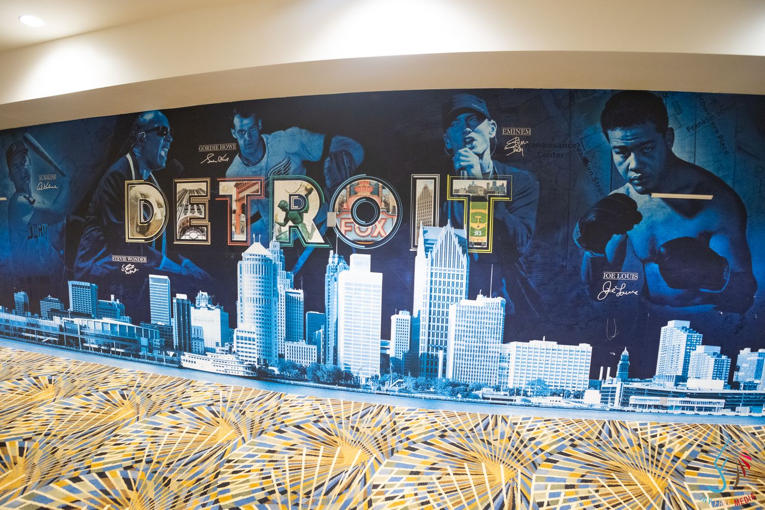 Large Detroit mural featuring city skyline and boxing figures with gold lettering on a decorative wall.