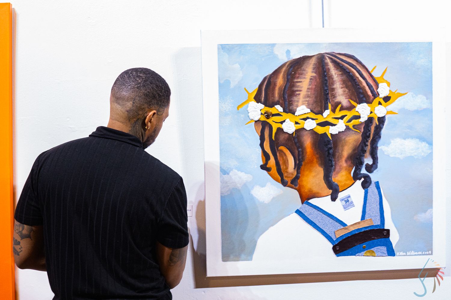 Man viewing a painting of a child with braids and gold star crown at an art gallery.