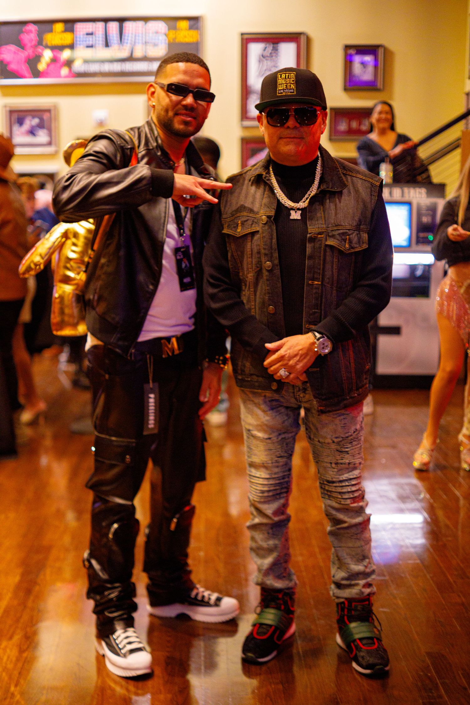 Two men in streetwear pose together inside an Elvis-themed Hard Rock venue.