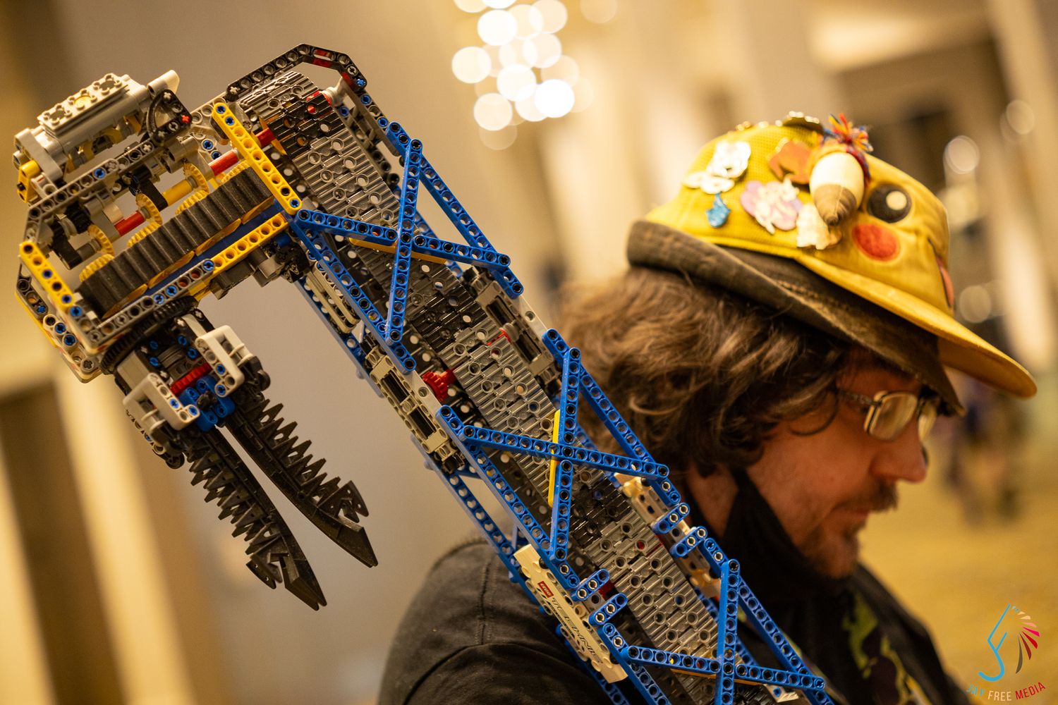 Creative LEGO crane hat worn by a person at a convention, showcasing intricate building techniques.