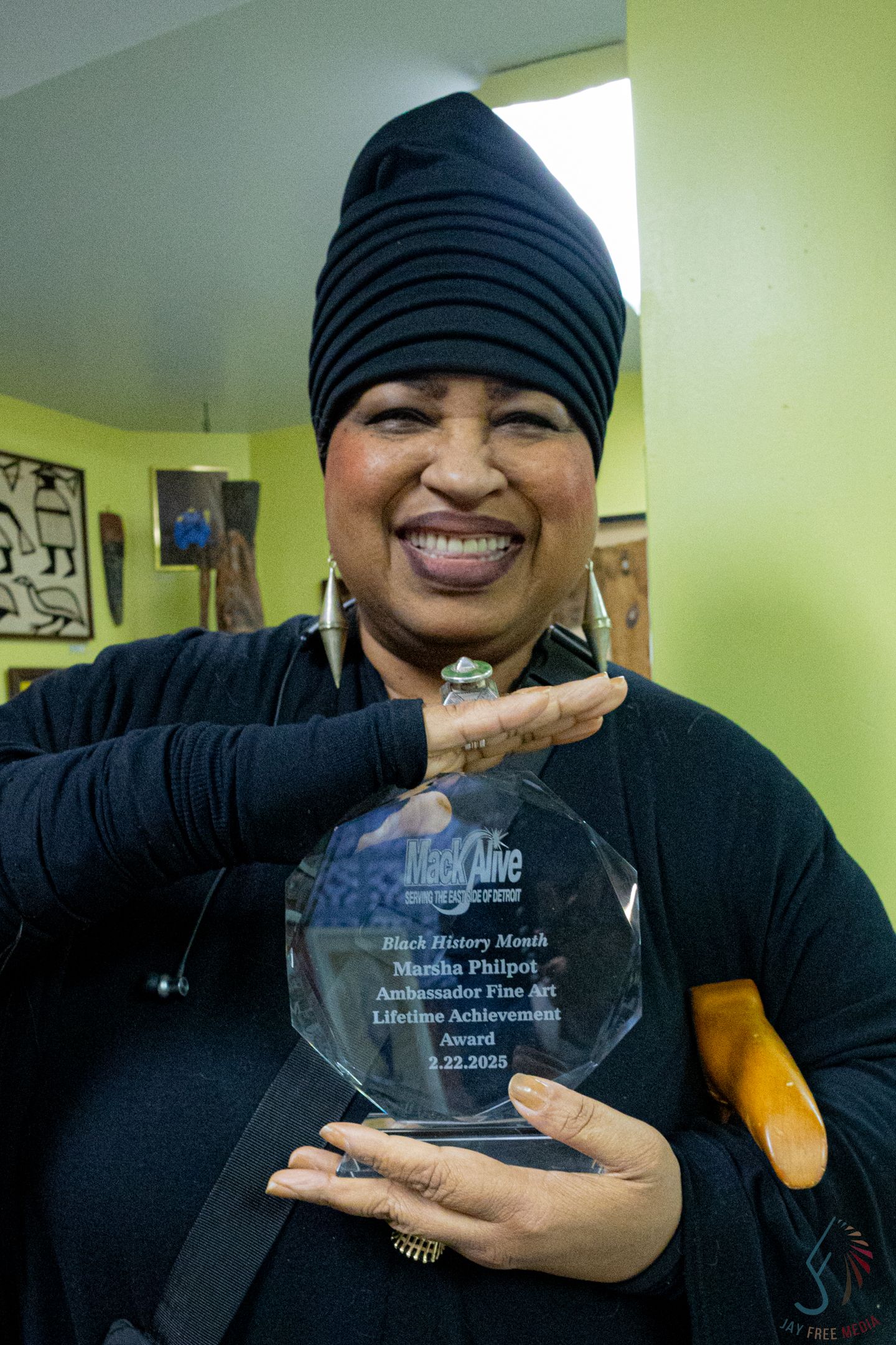 Martha Philpot proudly holds her Black History Month Ambassador Fine Art Lifetime Achievement Award from MacAlive, 2023.