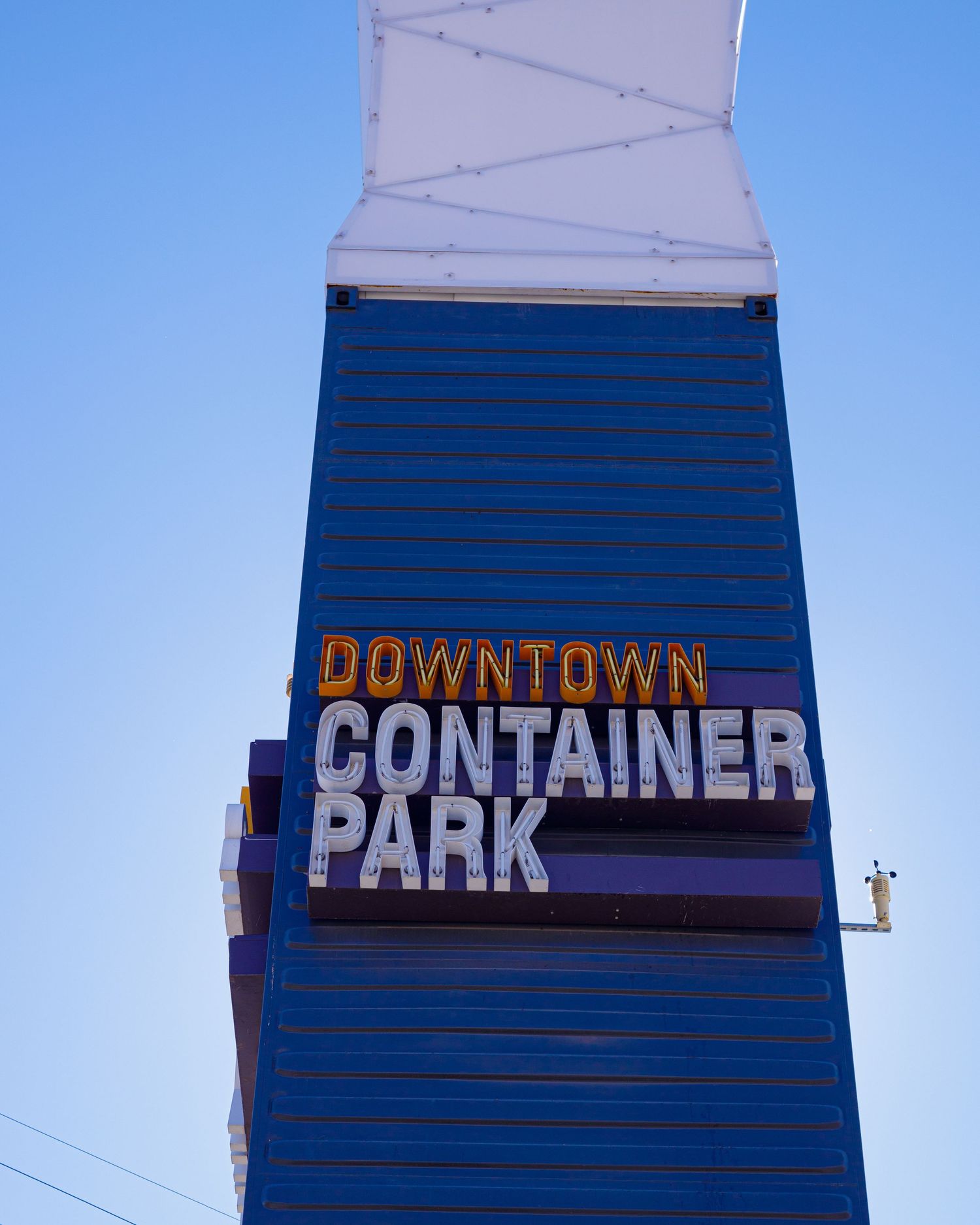 Downtown Container Park sign on a blue building against a clear blue sky in Las Vegas.