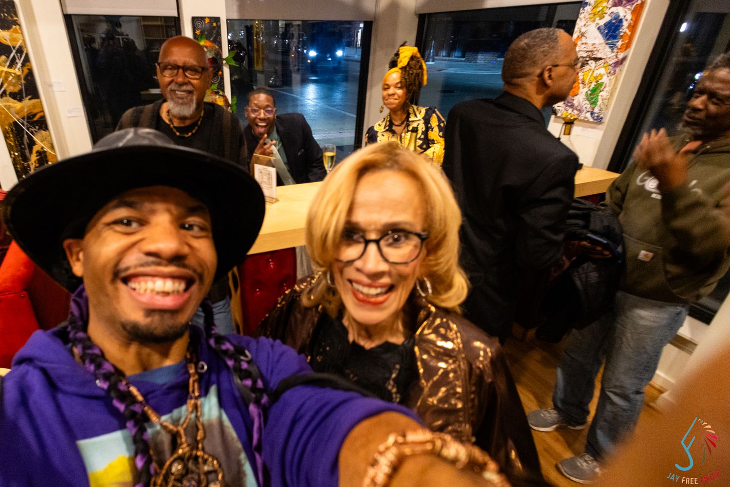 A group of diverse friends take a joyful selfie at an indoor social gathering event.