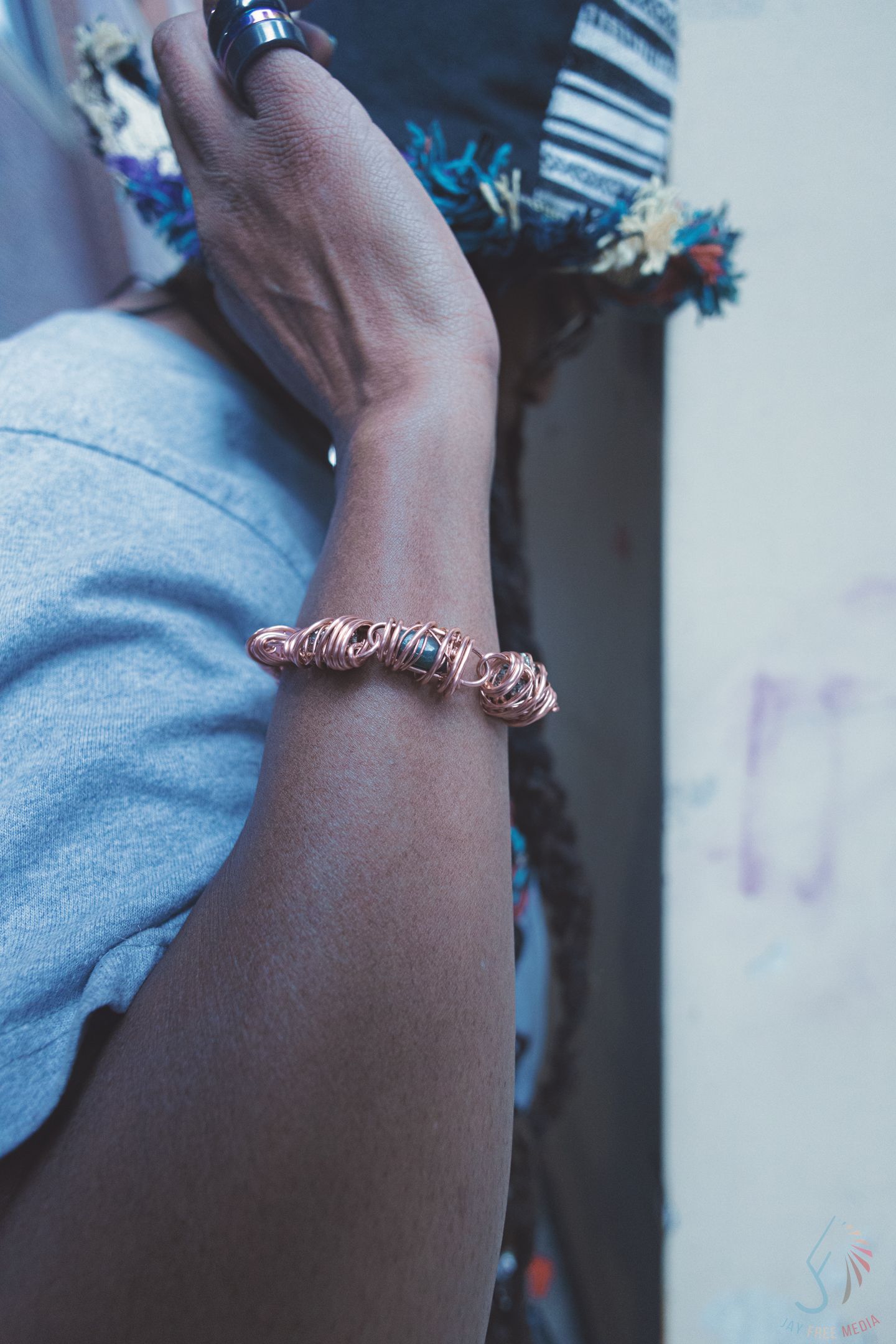 Close-up of a person's wrist adorned with a rose gold twisted bracelet, showcasing elegant jewelry styling.