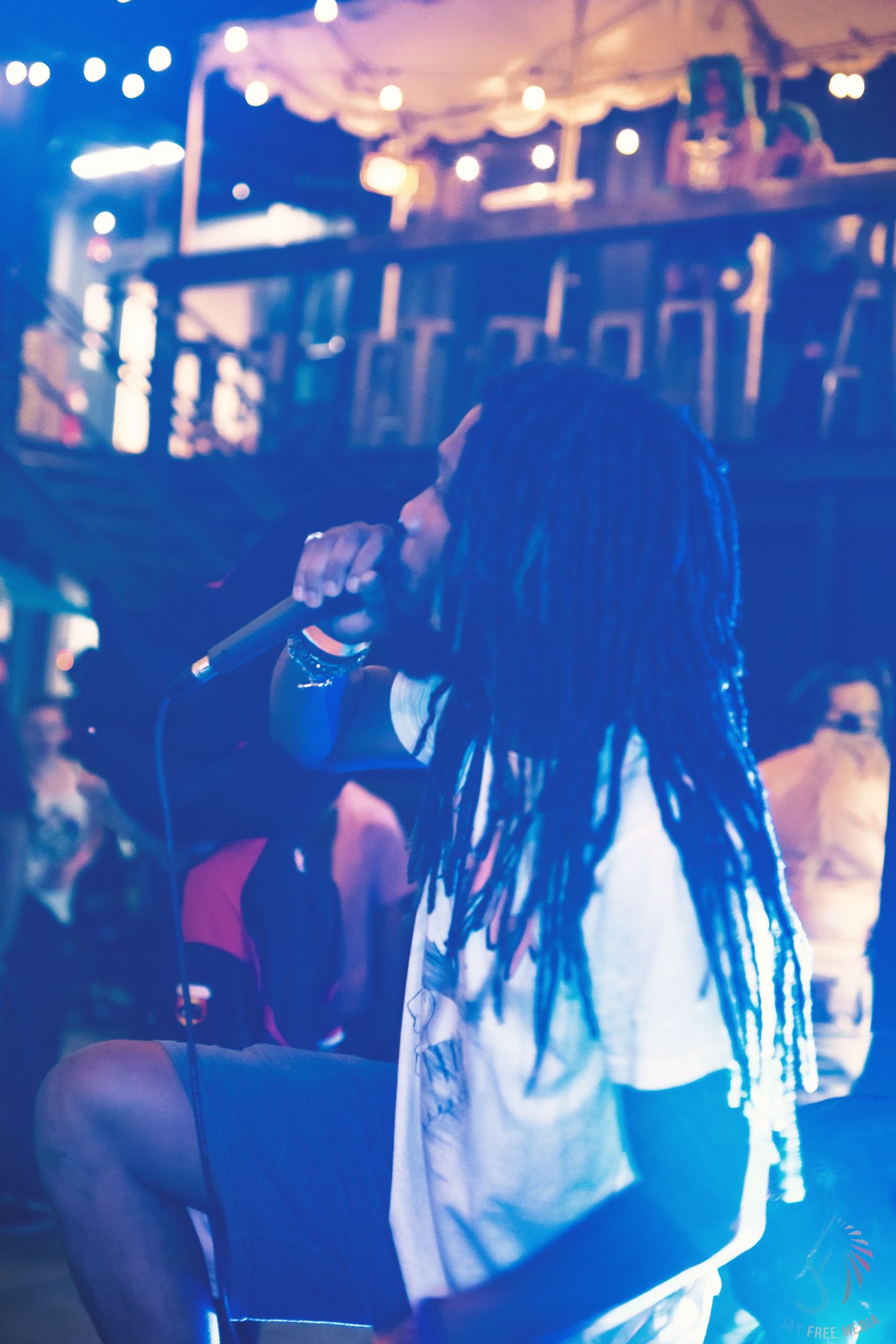 Crowd silhouettes at a nightclub bathed in blue lighting.