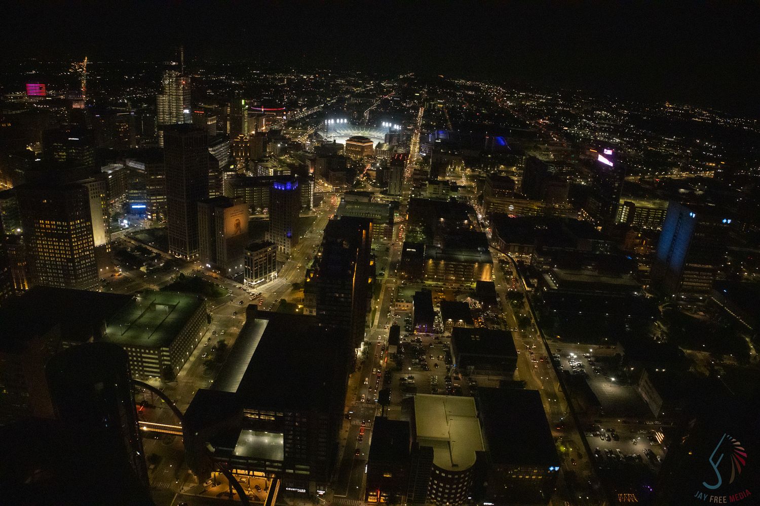 Aerial night view of a glittering city skyline with illuminated streets and buildings stretching into the horizon.