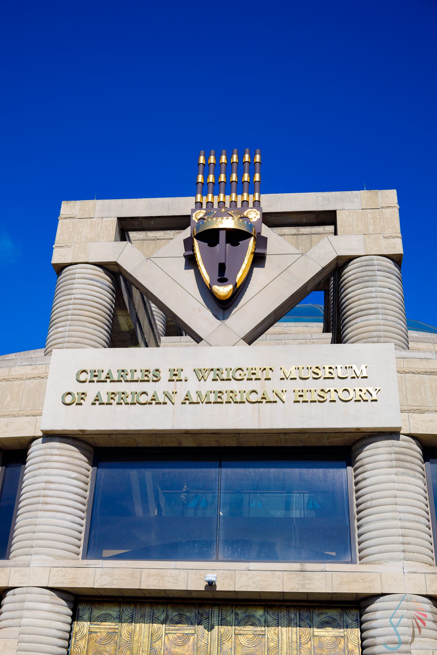 Exterior facade of the Charles H. Wright Museum of African American History in Detroit under a clear blue sky.