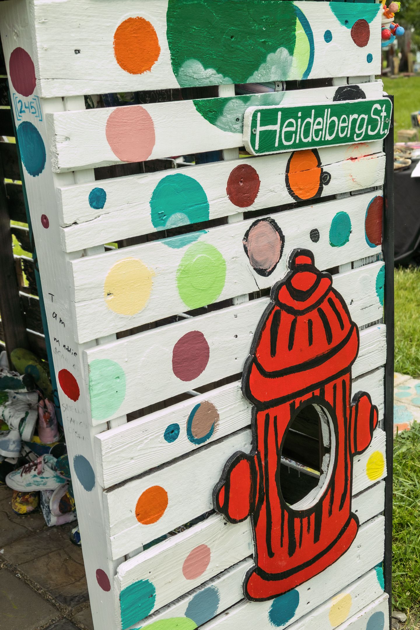 Colorful polka dot painted wooden board with red fire hydrant and Heidelberg St. street sign.