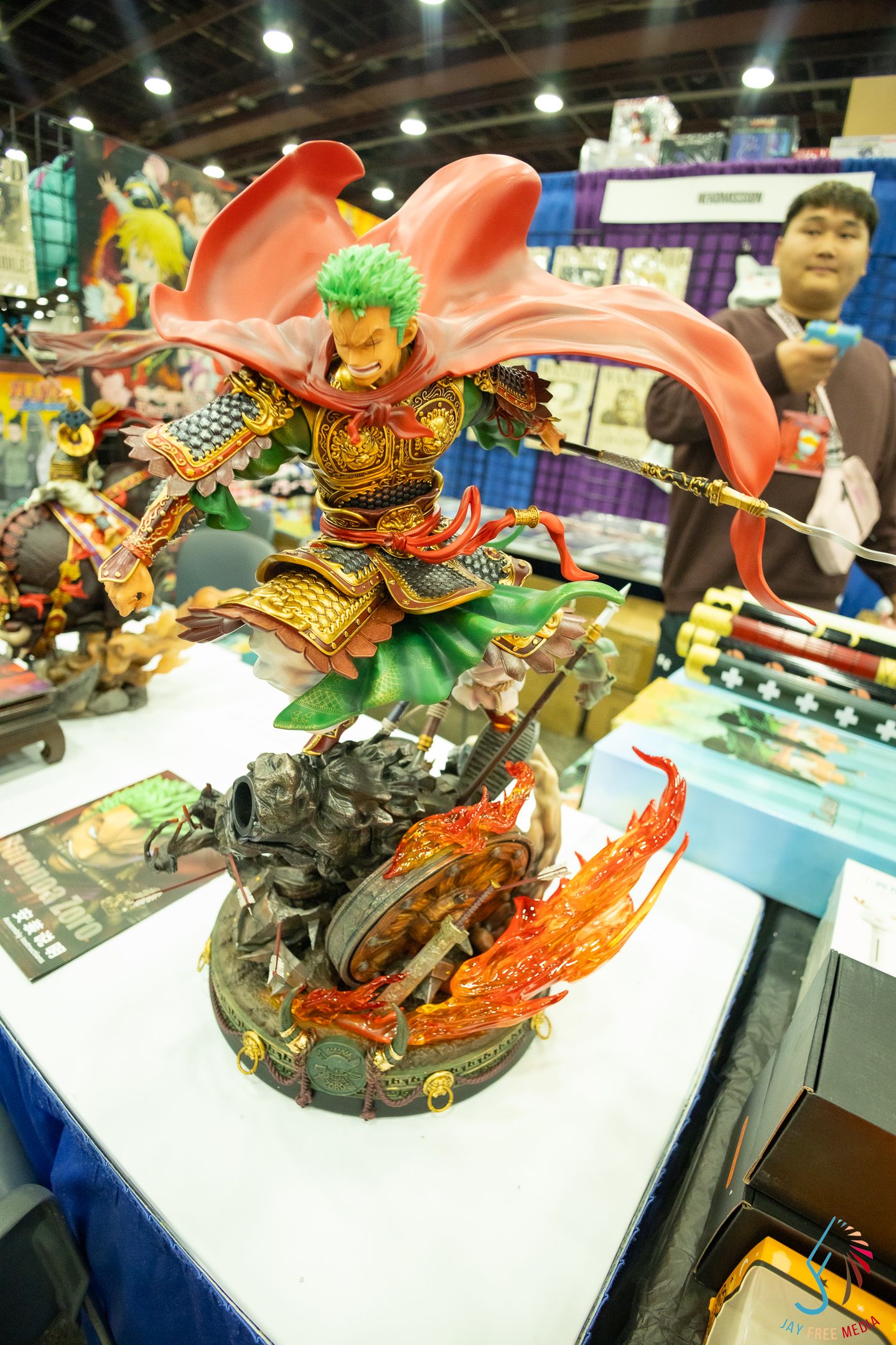 Detailed anime figurine of Roronoa Zoro from One Piece in samurai armor displayed at a convention.
