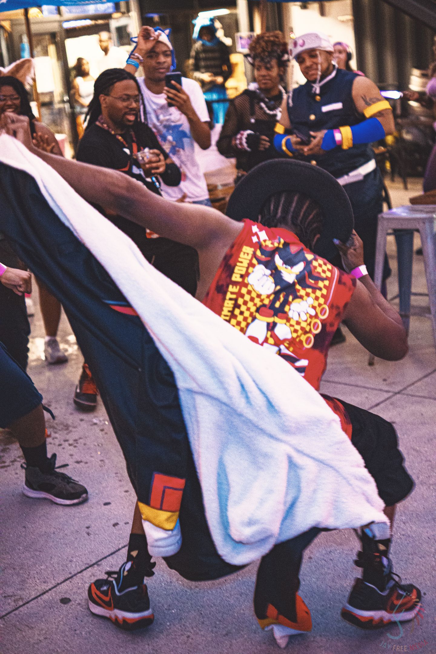 Dancers perform energetic street dance moves wearing colorful clothing and sneakers.