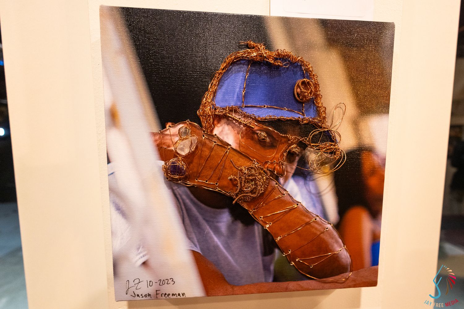 Mixed media artwork combining photography and wire sculpture of a blue and copper robot figure on canvas.