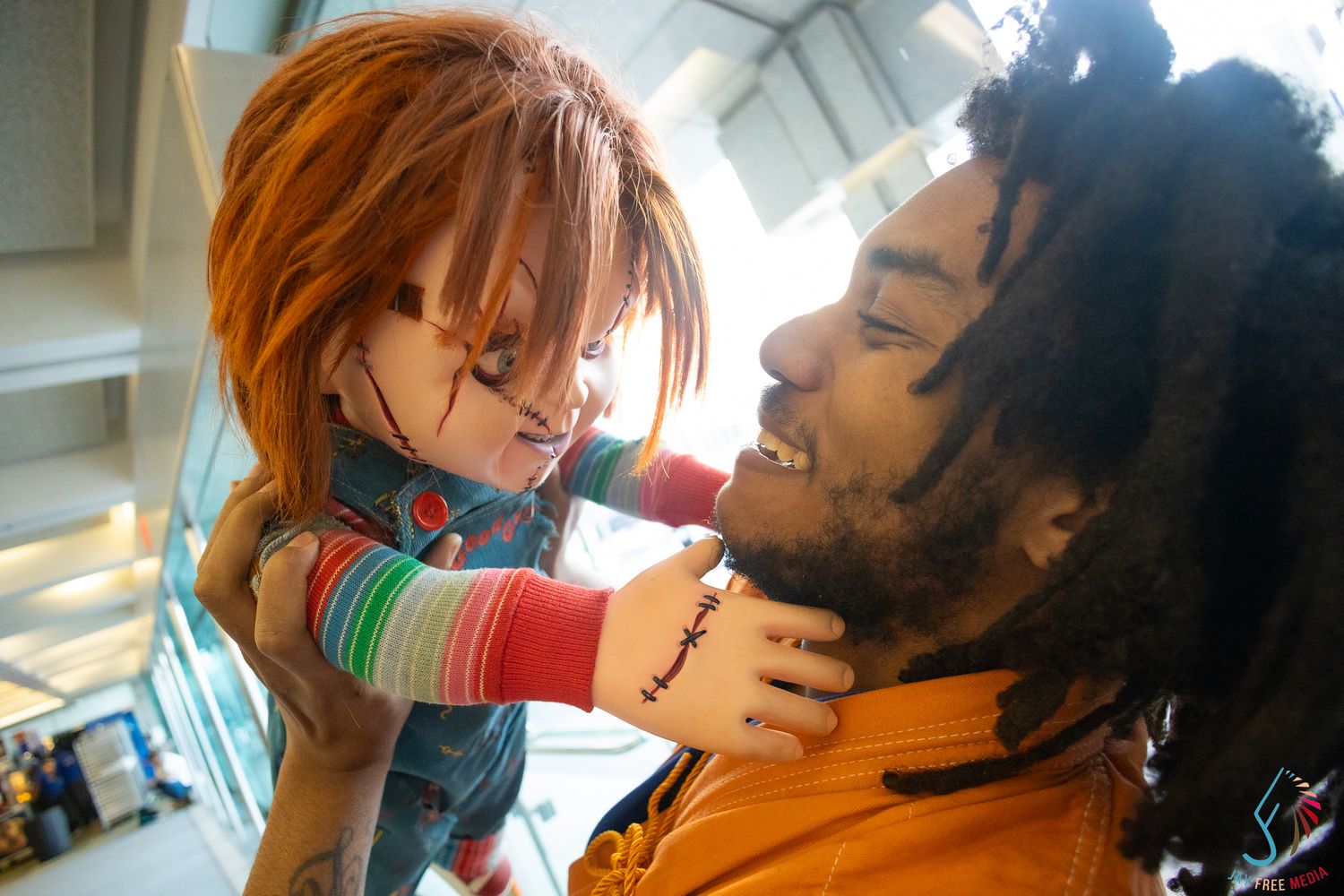 Chucky horror doll cosplayer menacing another convention attendee in playful posed photo.