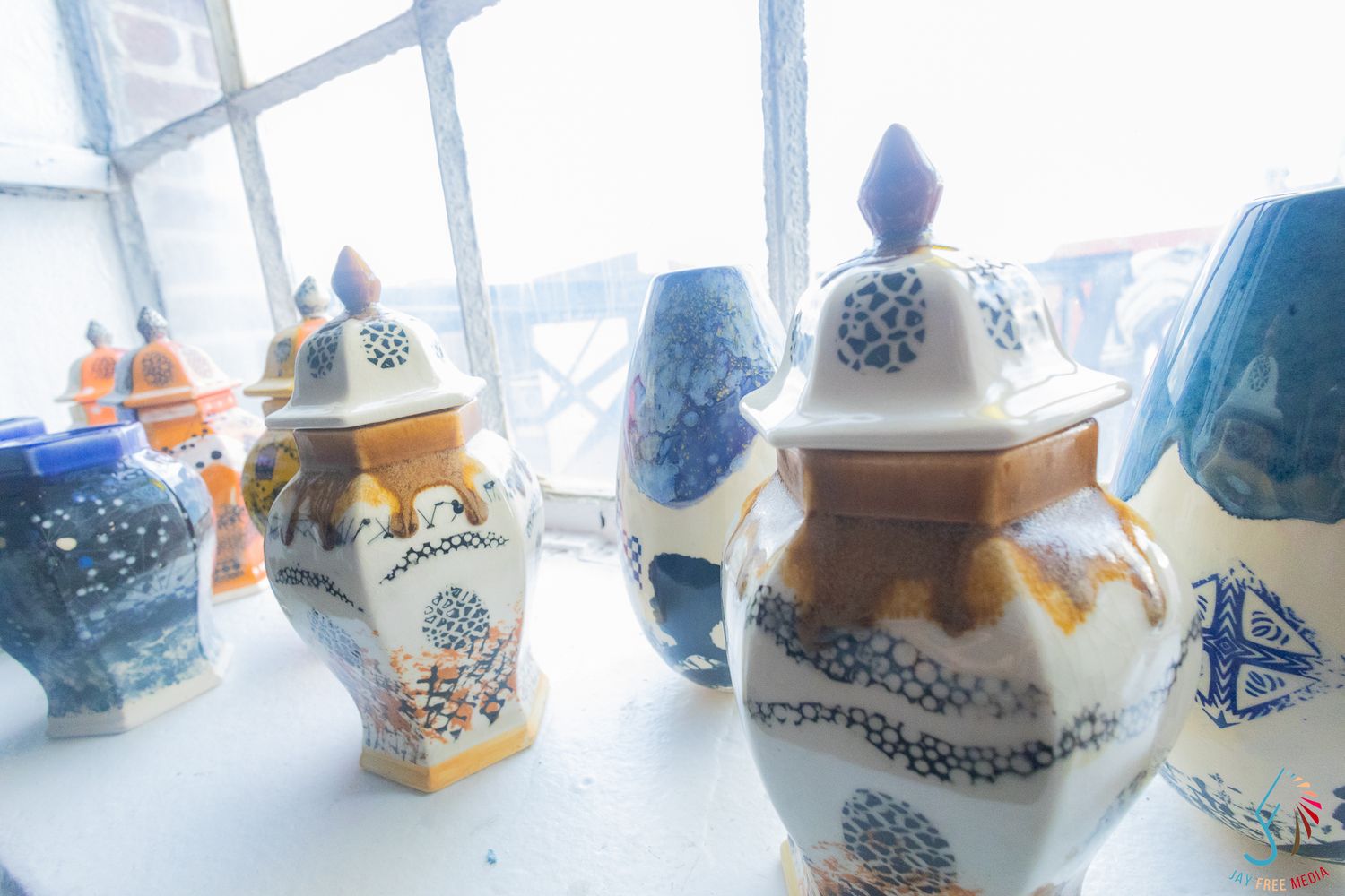 Decorative ceramic ginger jars with blue and white floral patterns displayed on a windowsill.