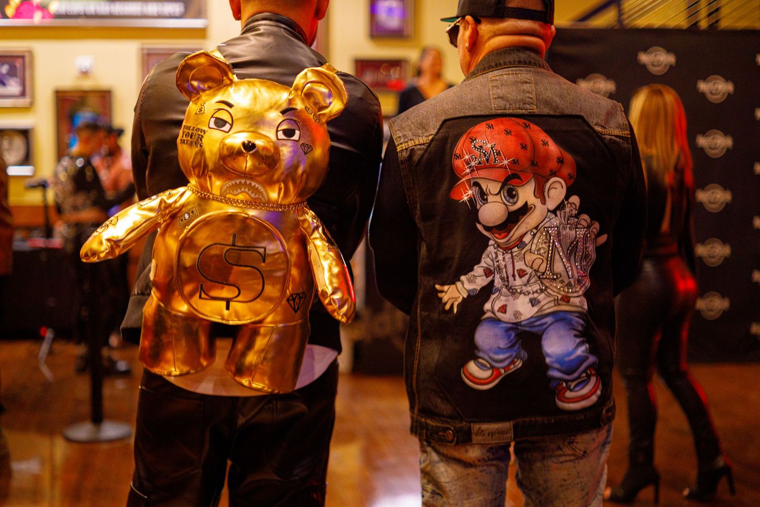 Gold bear statue and Mario-themed jacket displayed at a Harley-Davidson event.