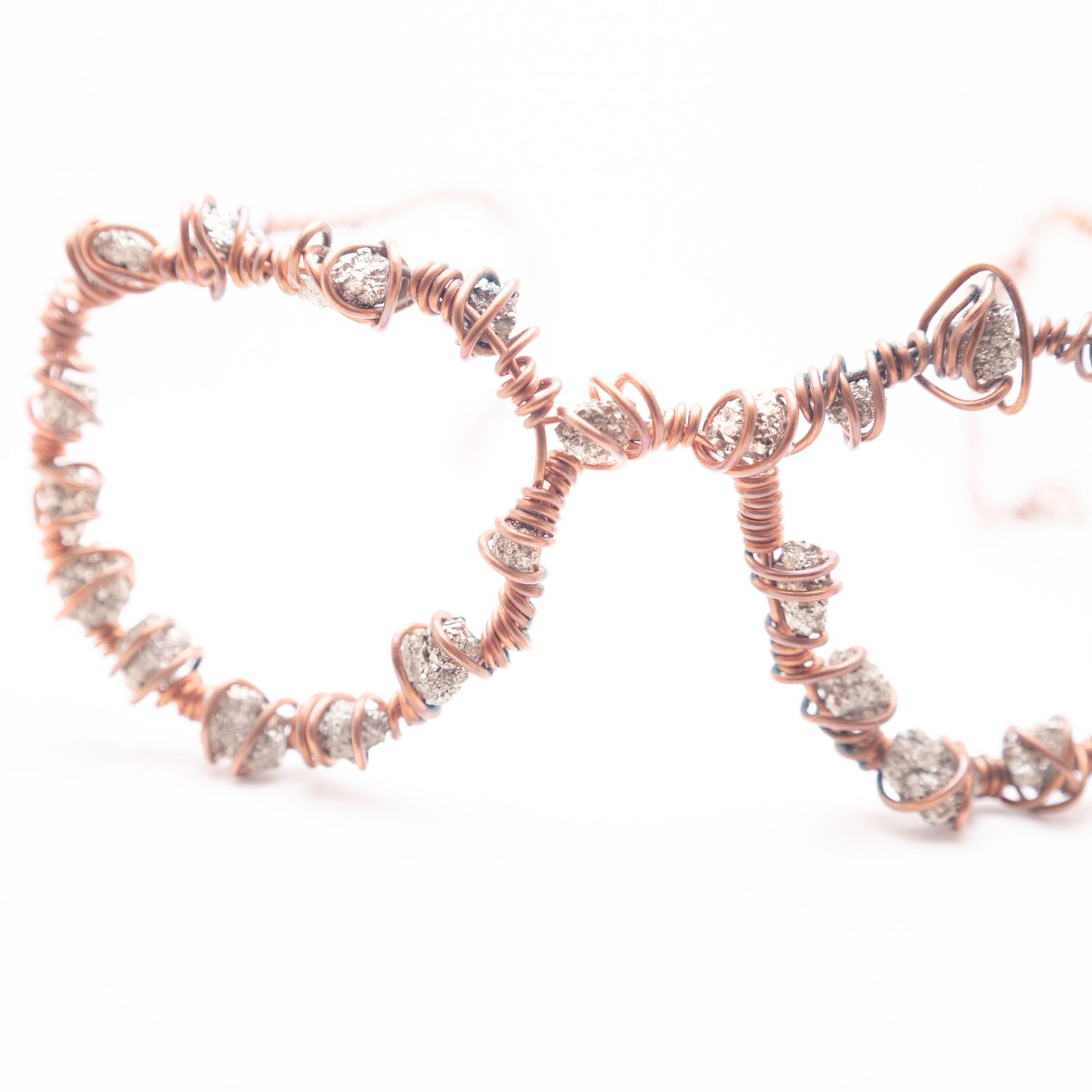 Rose gold copper wire wrapped hoop earrings adorned with sparkling crystal chip stones.