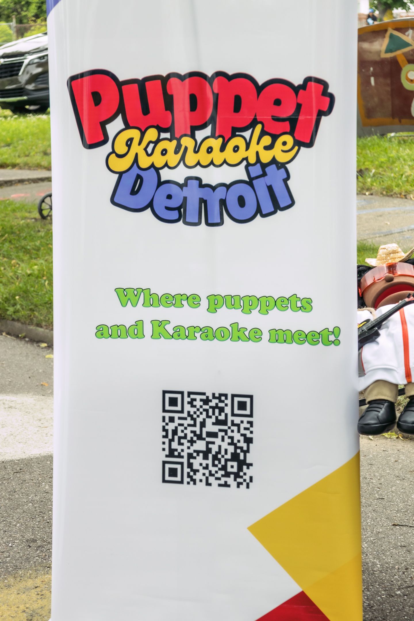 Puppet Karaoke Detroit banner sign with QR code reading where puppets and karaoke meet.