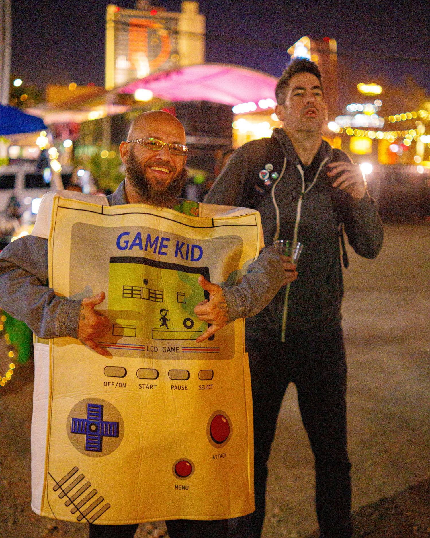 Man wearing a Game Kid costume at a colorful outdoor night event in Las Vegas.