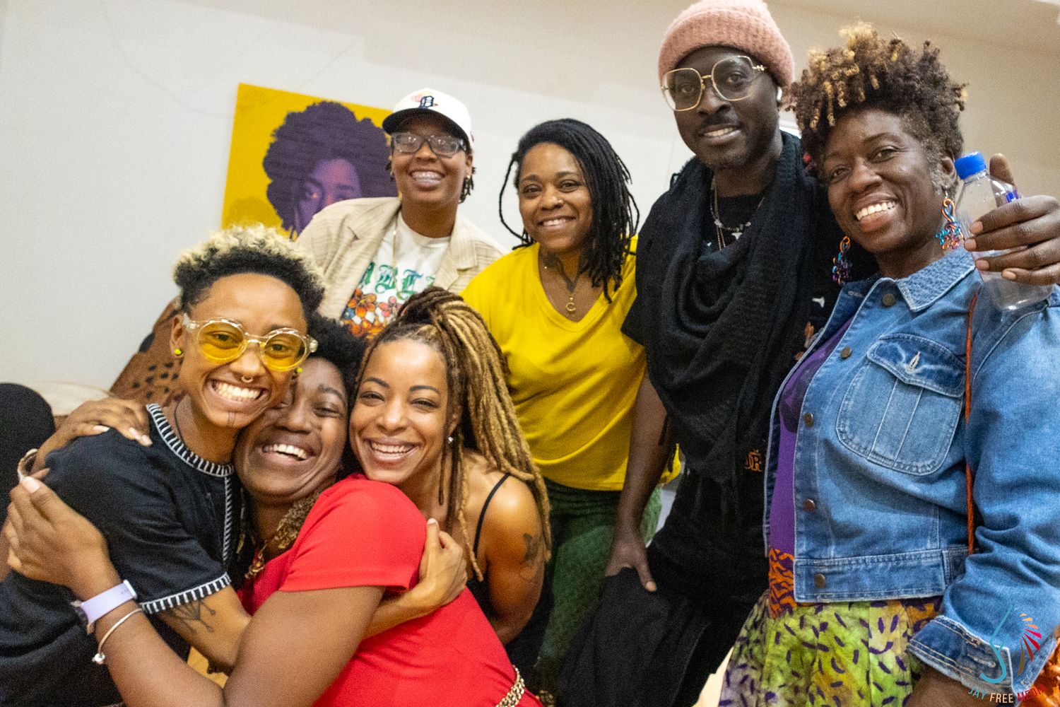A joyful group of friends posing together and smiling at a vibrant indoor social gathering.
