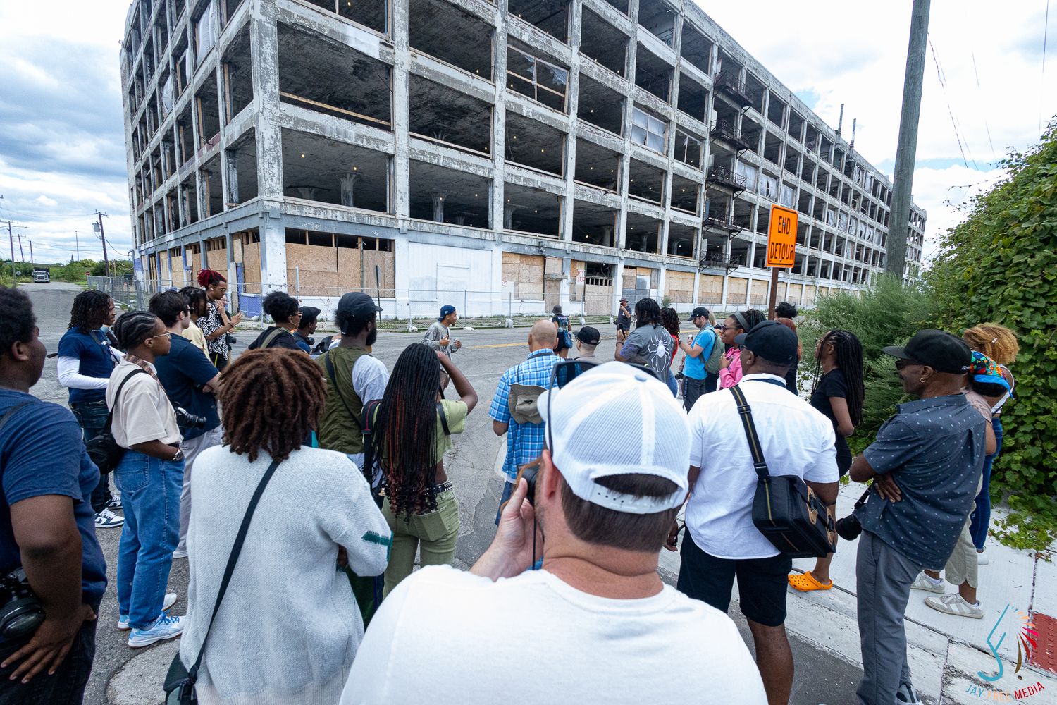 Group of diverse young photographers gathered outside abandoned urban building ruins.