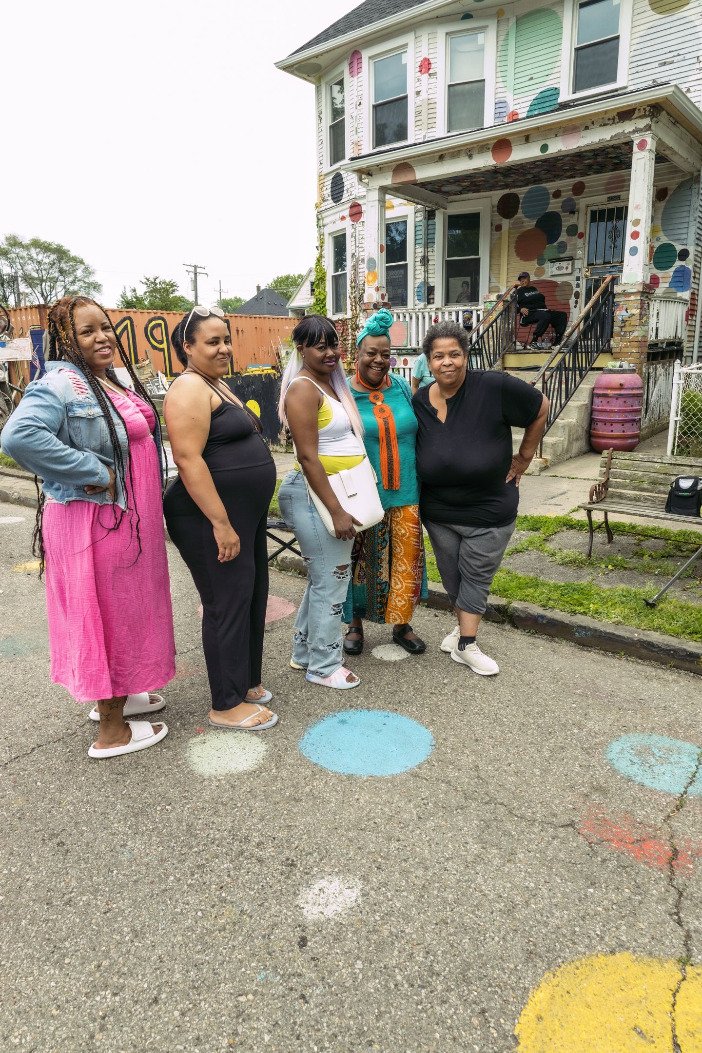 Five women pose together on a colorful street outside the Heidelberg Project art installation in Detroit, Michigan.