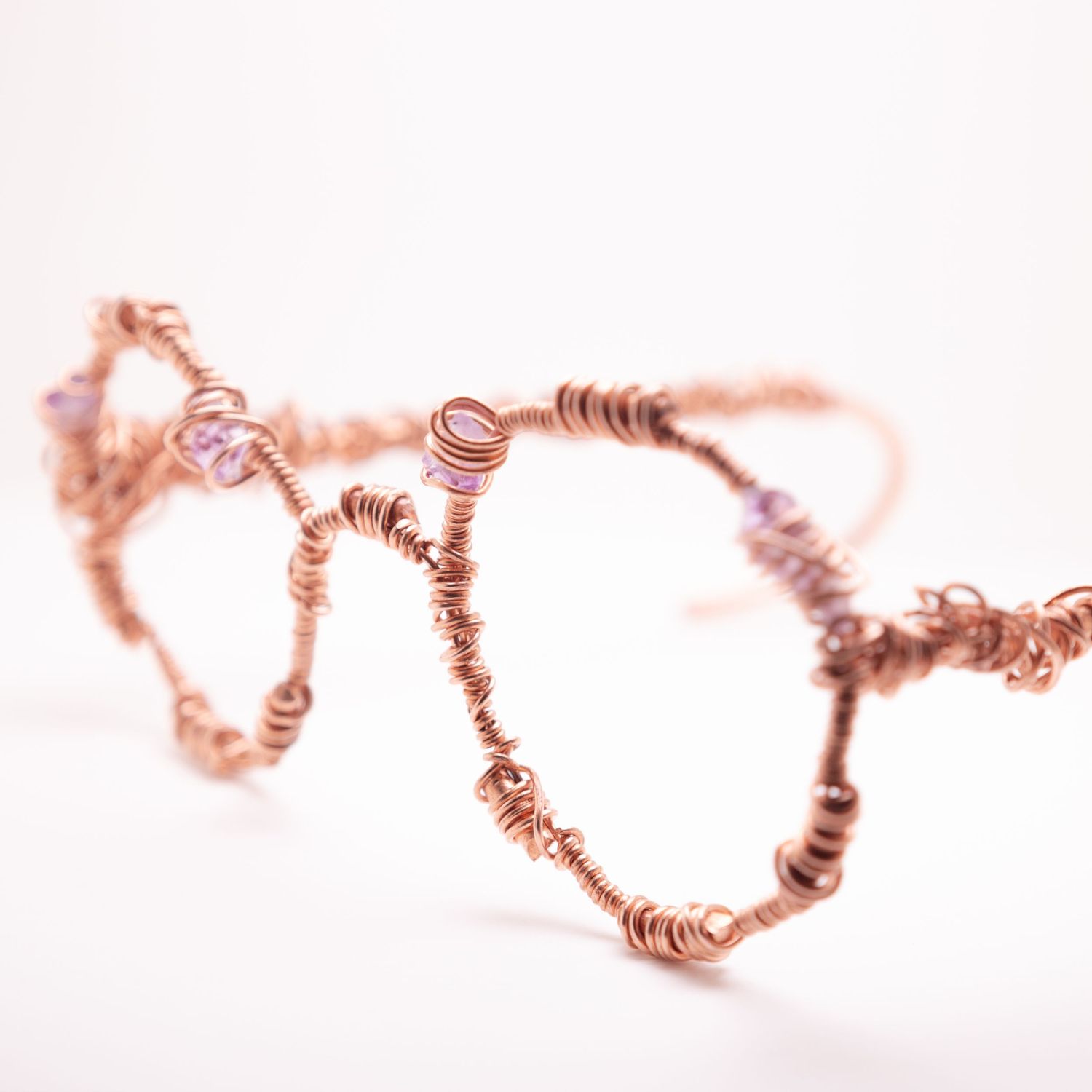 Handcrafted copper wire wrap glasses frames with intricate twisted coils and delicate pink gemstone accents.