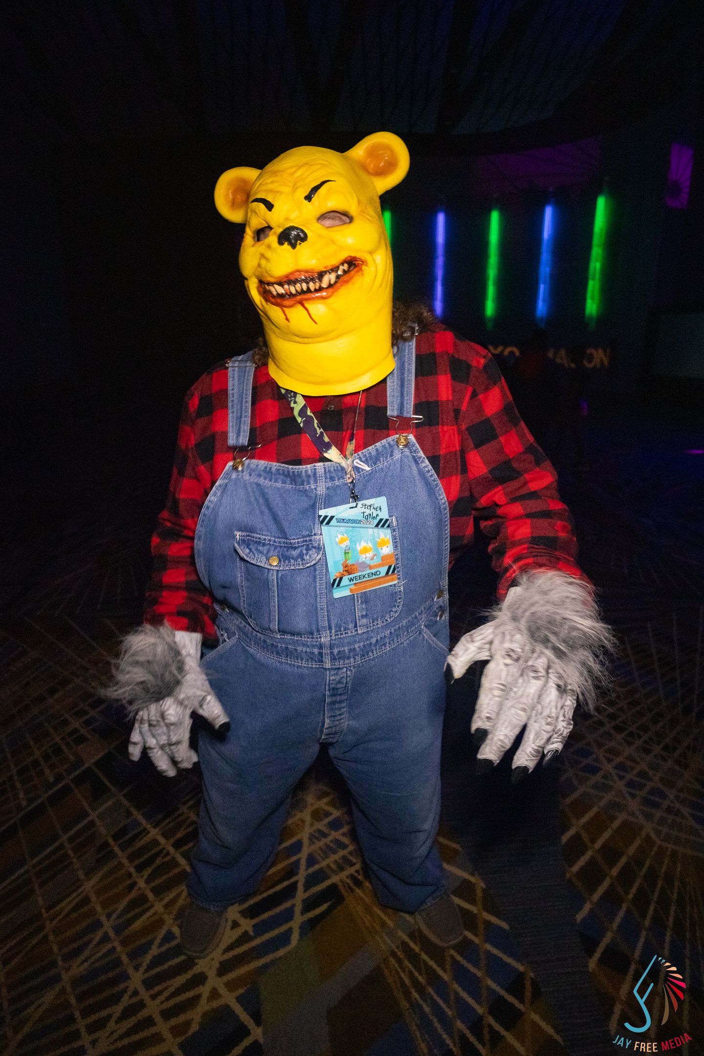 Creepy Winnie the Pooh Halloween costume with yellow bear mask, overalls, and werewolf hands.