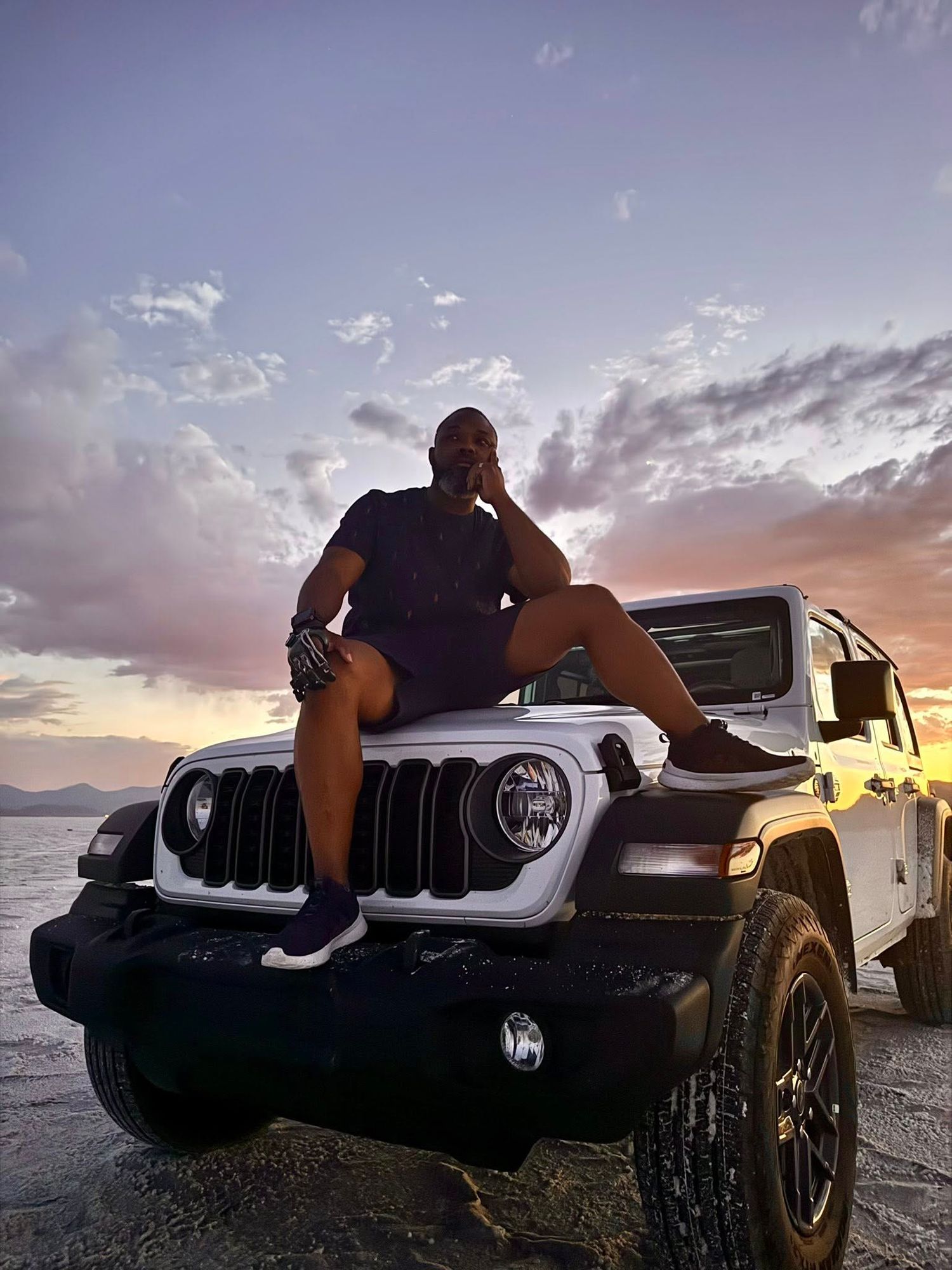 Dramatic sunset photoshoot featuring silhouettes posed on Jeep vehicles.