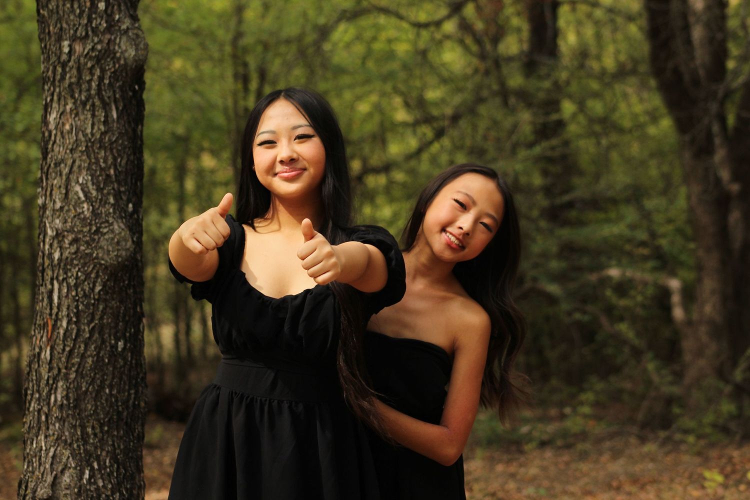 Friends posing together in a wooded area during autumn.