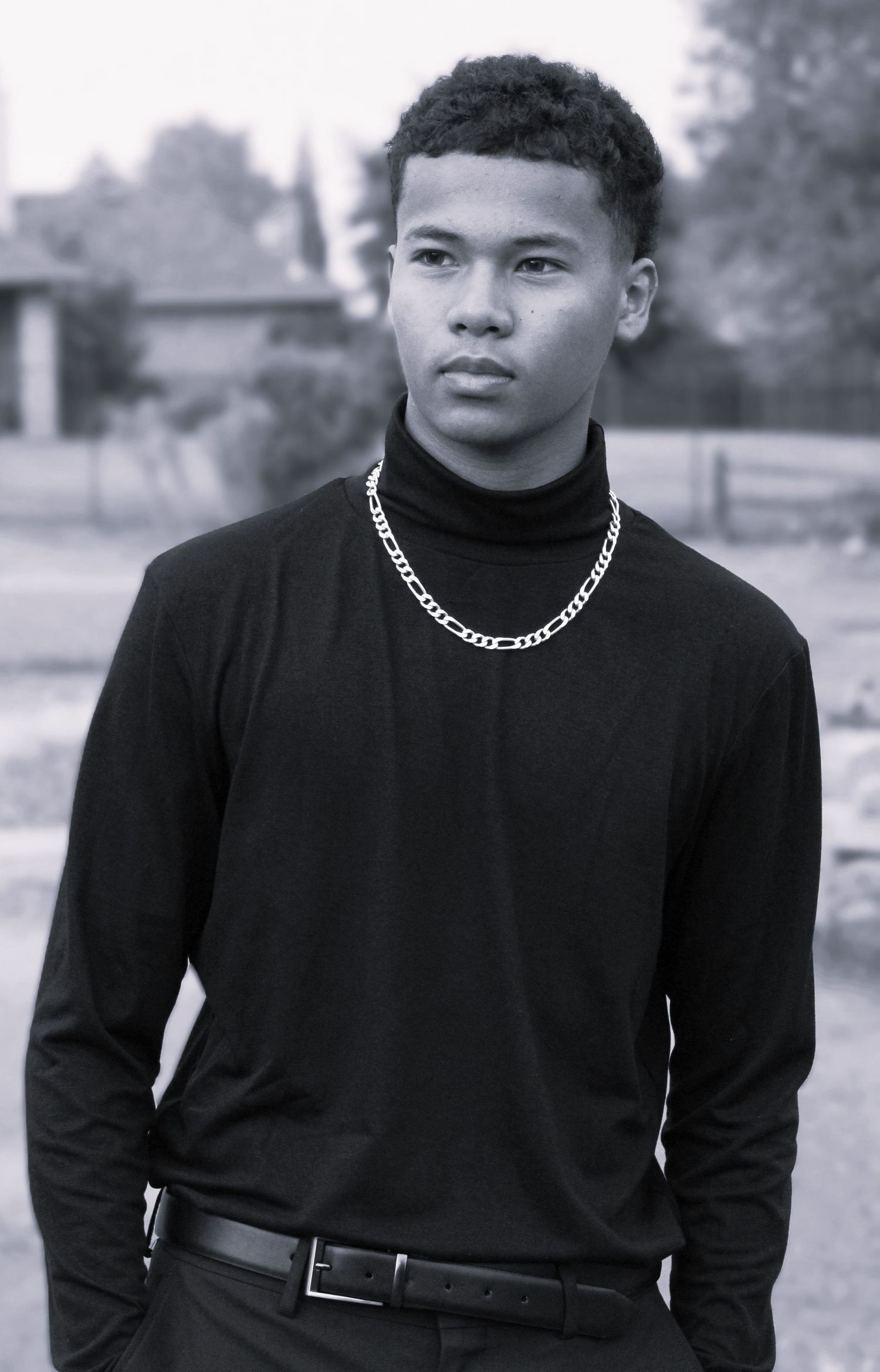 Black and white portrait series showing person in turtleneck and chain necklace.